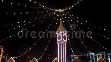 钟楼装饰圣诞灯，灯泡花环在城市广场新年市场。 相机<strong>飞来</strong>飞去