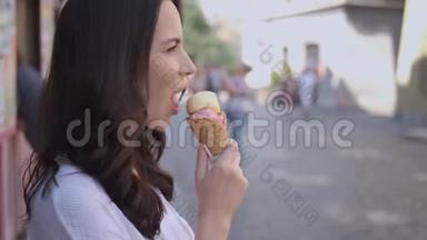 美丽的黑发女人吃美味可口的冰淇淋