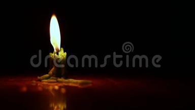 一支蜡烛在黑暗中燃烧，一支美丽的蜡烛在黑暗的房间里燃烧，一支温暖的绿色蜡烛在黑暗中静静地燃烧。