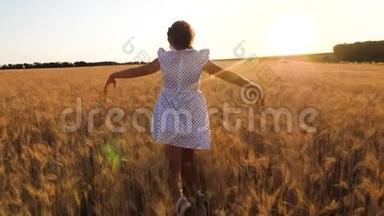 孩子们在一个领域扮演超级英雄。 快乐的小女孩正在一片成熟的麦子里飞翔，在夕阳的背景下。 慢慢慢慢