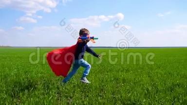 一个<strong>快乐</strong>的孩子想象着一个超级英雄，跑<strong>过</strong>绿草地，抱着飞机。 <strong>快乐</strong>的男孩在户外玩耍