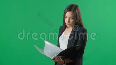 年轻快乐女商人的肖像与黑色文件夹，隔离与绿色屏幕背景。 商业成功