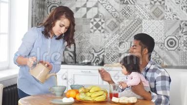 快乐的一家人早上一起在厨房的家里吃早餐