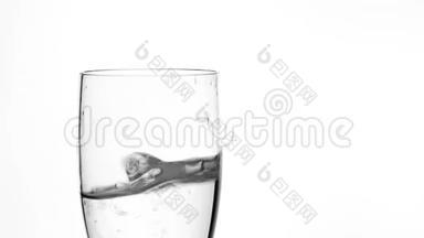 在白色背景的透明饮料玻璃中填充冰块和淡水。 清凉饮料和点心。