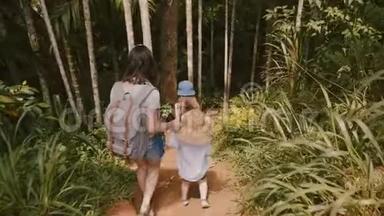 镜头跟随着幸福的年轻妈妈和<strong>两个小孩子</strong>一起走在陡峭的异国情调的森林小径上，慢动作。