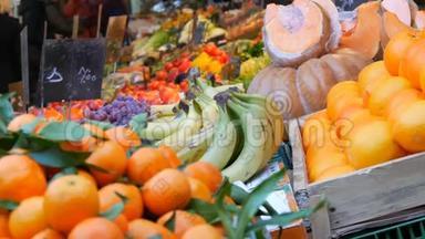 在前景橘子与绿叶和异国水果。 蔬菜市场。 各种蔬菜种类繁多