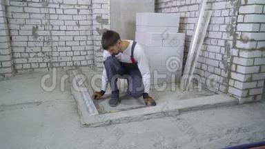 建筑工人用角尺和施工尺测量混凝土基层