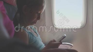 可爱的女孩乘飞机旅行，在飞行中使用数字平板电脑。 与孩子一起<strong>出国</strong>旅行的概念。