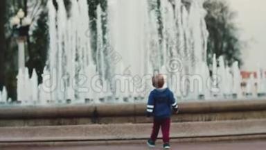 一个小男孩在喷泉前散步。 与<strong>父母</strong>同行.. <strong>父母</strong>照料