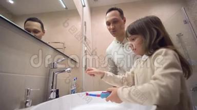 幼儿晨间卫生，小父亲在镜子前教女儿刷牙和监测<strong>口腔健康</strong>