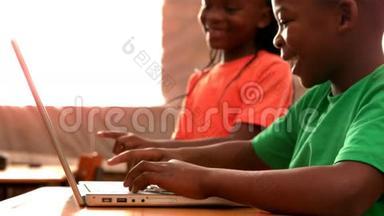 小学生在教室里用笔记本电脑