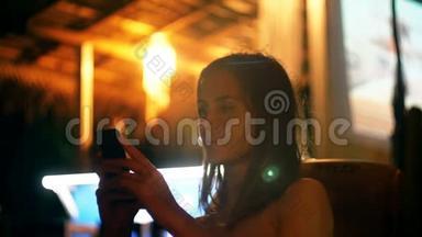 快乐迷人的年轻女商人微笑使用智能手机购物应用程序在大气之夜户外<strong>酒廊酒</strong>吧咖啡馆。