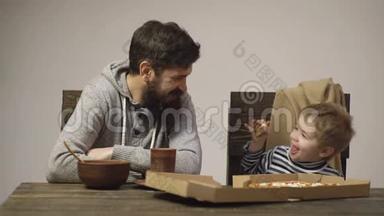 快乐的父亲和孩子吃披萨。 男人和男孩在家庭聚会上吃披萨。 朋友吃披萨，吃披萨
