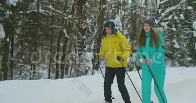 在情人节前夕，穿着蓝色夹克衫的微笑女孩和男朋友一起在森林`滑雪。 慢慢慢慢