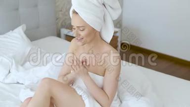 中年美丽的金发女人淋浴后滋润双腿