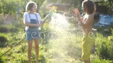两个孩子在夏天的花园里玩洒水。 哥哥姐姐，暑假.. 热水游戏