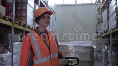 一位辛勤工作的妇女，穿着制服的工人，在仓库的一排排货架之间用<strong>箱子拉</strong>动手推车