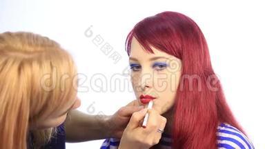 设计师用<strong>一支</strong>红色<strong>铅笔</strong>画出模特嘴唇`轮廓。 化妆师用刷子在女人身上涂口红`