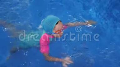 小女孩正在学习游泳在游泳池潜水和漂浮在水中。