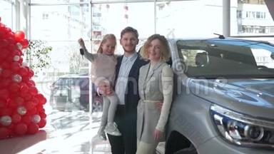 幸福的消费家庭夫妇和小女孩在手上的肖像展示了在<strong>汽车</strong>陈列室购买的<strong>汽车钥匙</strong>