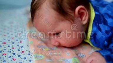 婴儿<strong>躺</strong>在他的肚子上，大眼睛在床上为<strong>新生儿</strong>打开。