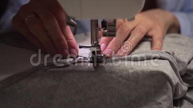 女人`用缝纫机缝制手。 女人`手缝在缝纫机上。 时尚，创造和剪裁。