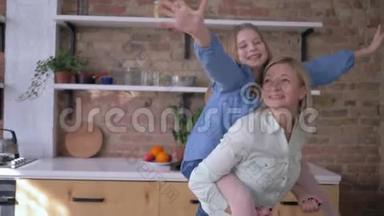 和<strong>妈妈</strong>一起玩游戏，有趣的小女孩和<strong>妈妈</strong>坐在后面，<strong>在家</strong>庭厨房里做手臂伸展的飞机