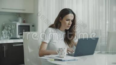 疲惫的<strong>女人</strong>在家里用笔记本电脑。 严肃的<strong>女人</strong>在厨房<strong>喝茶</strong>