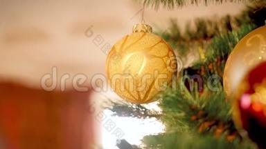 客厅圣诞树上悬挂和旋转的金色闪闪发光的宝珠特写4k视频