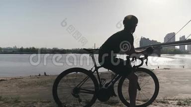 专业瘦身骑自行车的骑自行车的人看着河上的一座桥，车通过。 Cyclist做梦和思考