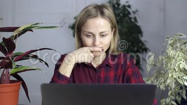 疲惫的女人，按摩她的头，减轻长时间工作的压力，看着笔记本电脑屏幕。
