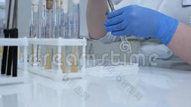 一位年轻的女化学家正在做一项化学物质的科学实验。 研究人员将化学品滴入试验管中