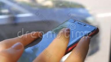 女人用手机骑公交车坐在窗边。 屏蔽手机坏了..