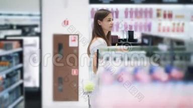 美丽的女孩在<strong>化妆品店</strong>的货架上，慢动作，稳定镜头