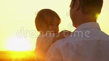 快乐的爸爸抱着他的手臂，小女儿在公园里的阳光明媚。 爸爸带着一个小孩走路