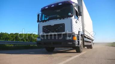 低视野卡车与货物拖车在公路上行驶和运输货物。 卡车在乡间穿梭