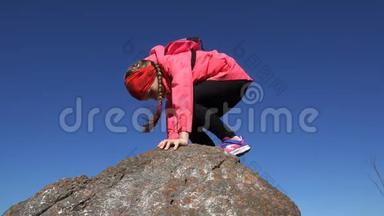 女孩爬上大石头