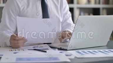<strong>商务</strong>人士使用笔记本电脑及文件的特写镜头