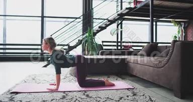 早上瑜伽姿势年轻女士在家里练习，在有大窗户的客厅里练习，女士坐在上面
