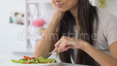 女人沉<strong>重地</strong>叹息着看着蔬菜沙拉，没有食欲，饮食