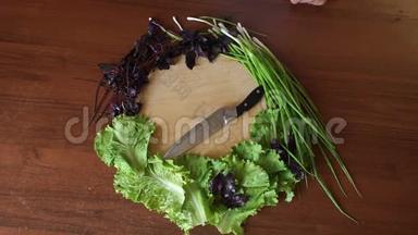 新鲜的蔬菜和草药摆在一个圆形的切割板上，刀在桌子上。