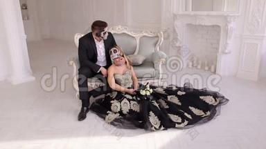一对打扮得诡异的万圣节夫妇坐在老式房间的老式沙发上。