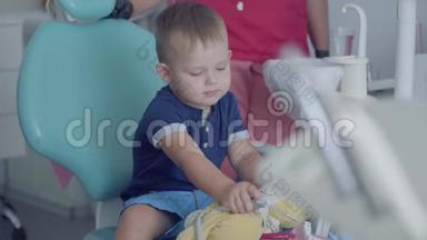 可爱的小男孩坐在牙医办公室的椅子上玩医疗工具。 <strong>免费儿童</strong>探访