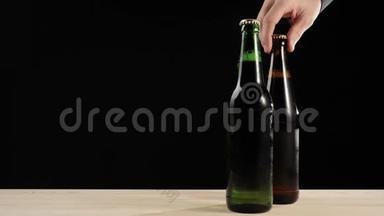 新鲜<strong>啤酒</strong>。 手拿着一个棕色的瓶子，里面有<strong>美</strong>味的手工<strong>啤酒</strong>，靠近绿色的瓶子，还有木桌上的<strong>啤酒</strong>