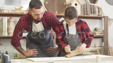 安全眼镜的木匠小徒弟或小学生在工作时使用飞机
