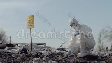 生物危害，女科学家生态学家穿着制服，戴着防护手套，从大垃圾中取样