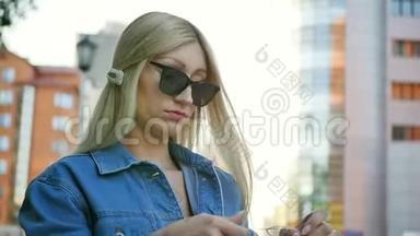 一个年轻的女人试图解开长长的白色耳机线。 一位金发女郎手中拿着科学老师的画像