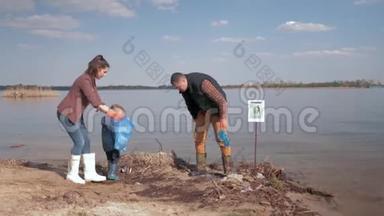 环保解决方案，儿童男孩帮助母亲和父亲的志愿者清理肮脏的河岸塑料