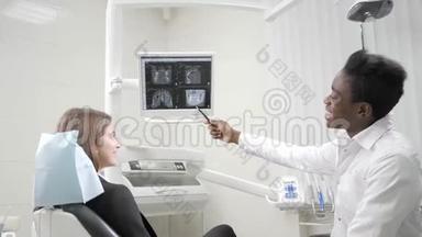 年轻的非裔美国男医生牙医体贴地看着显示器x光。 医学、卫生、口腔科