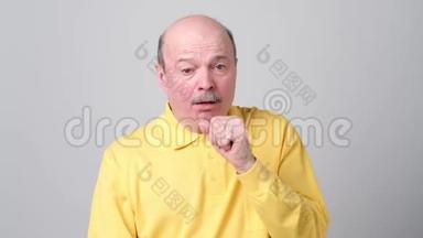 成熟的西班牙裔男子穿黄色t恤男子咳嗽生病。